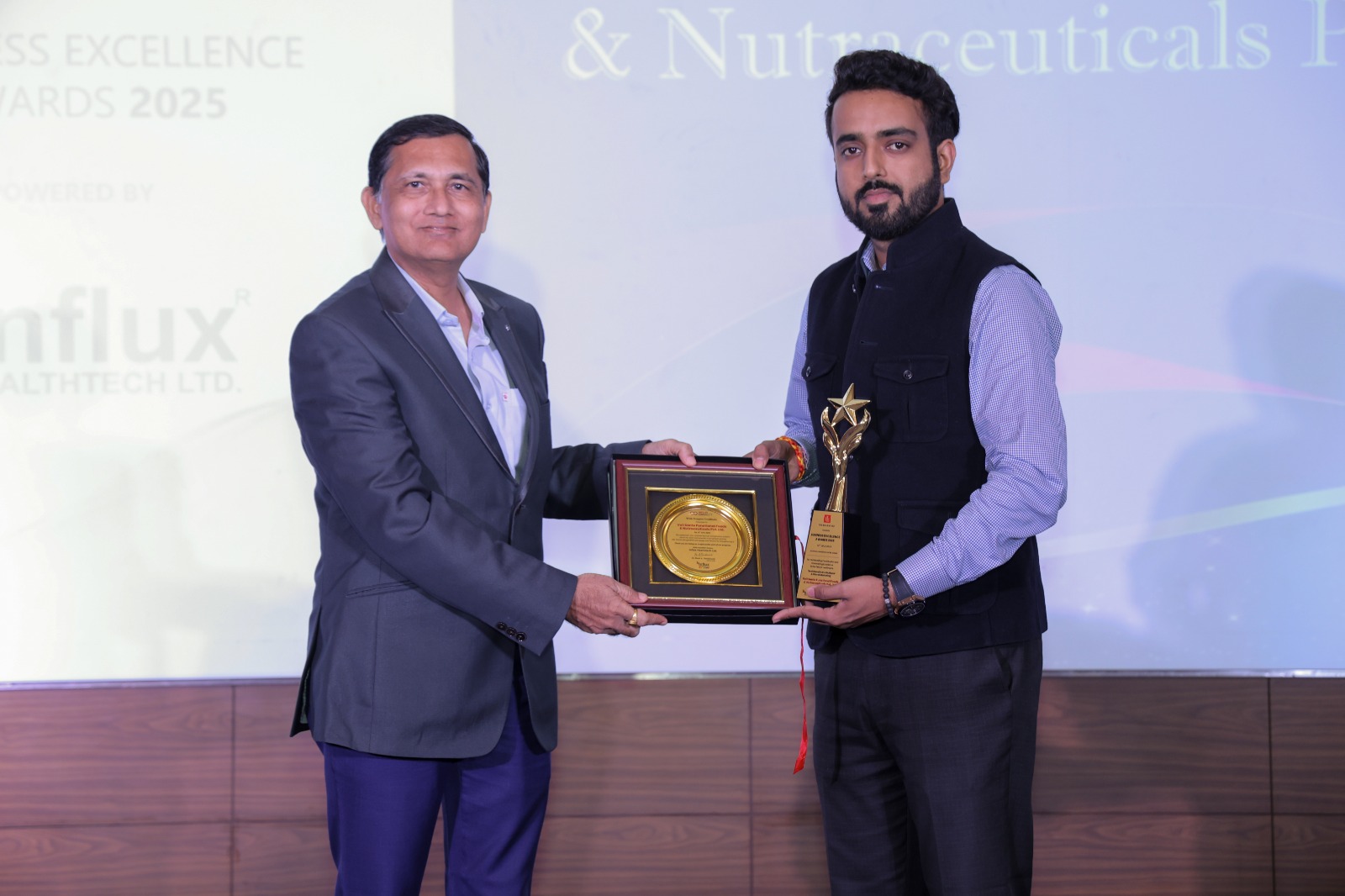 Voll Sante team receiving 'Best Brand in Institutionals and Ethical Marketing' award at Influx Connect 2025, with backdrop showing event branding and award presenter Mr. Nilesh Gandhi at Jio Convention Center, Mumbai